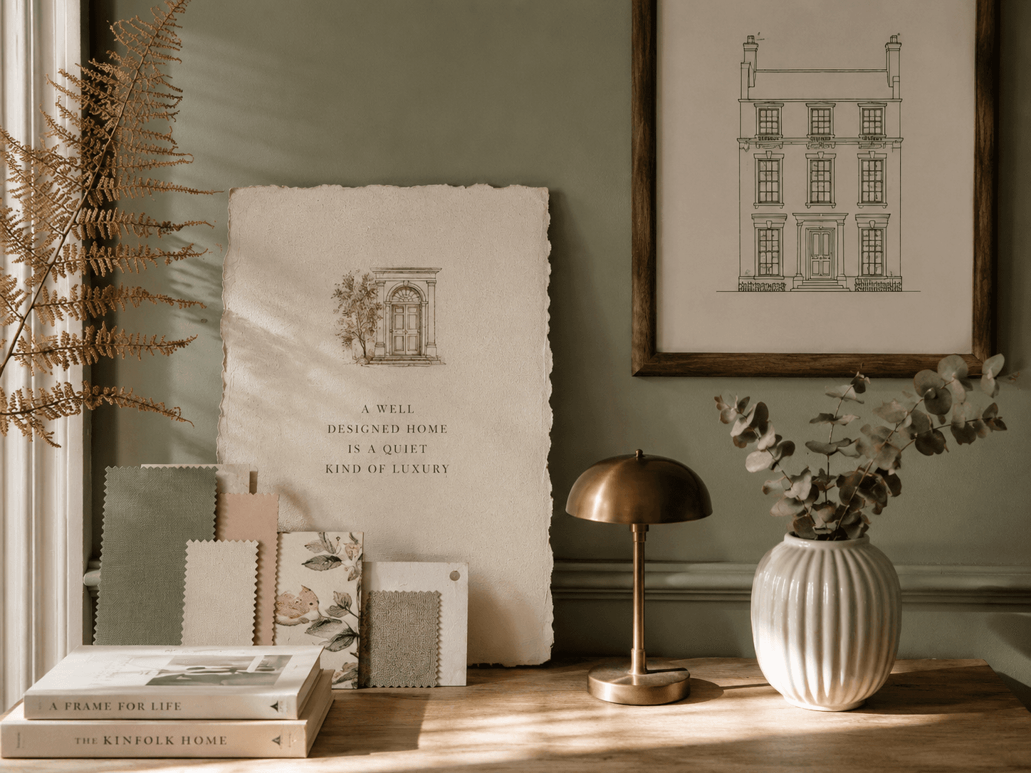 A sage-green Georgian interior: a framed line drawing of a townhouse, a torn parchment card, a brass lamp, eucalyptus and fabric swatches, the House of Willow Alexander.
